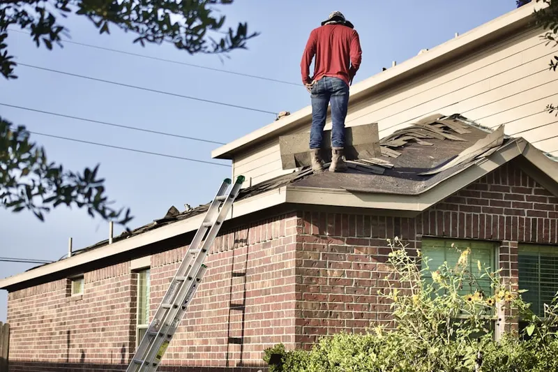 Professional roofer working on a residential roof in Hollis